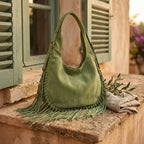 Green bag with fringe tassel styled in a warm Mediterranean setting