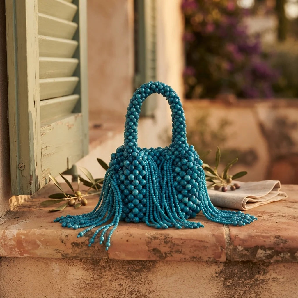 Blue beaded fringe clutch bag styled in a warm Mediterranean setting