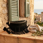 Black black fringe belt bag styled in a warm Mediterranean setting