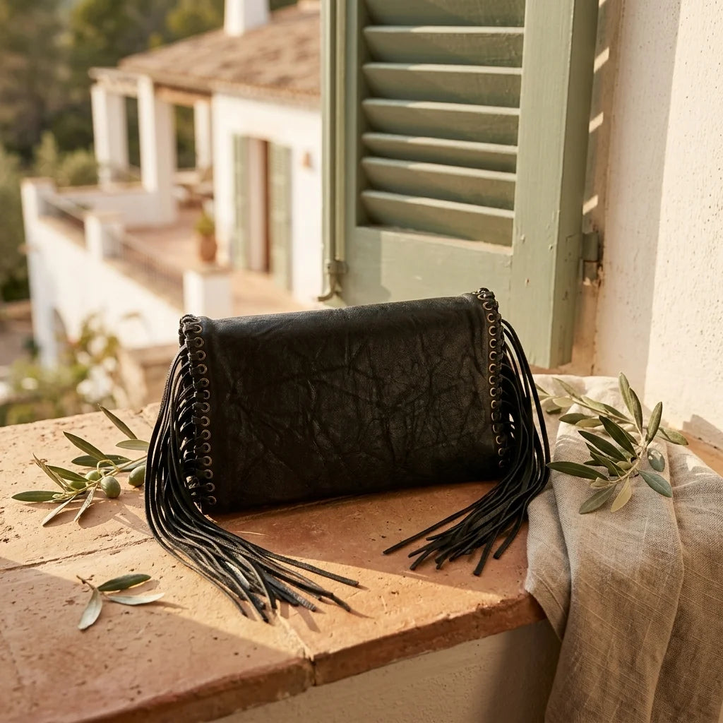 Black black fringe clutch bag styled in a warm Mediterranean setting