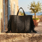 Black black fringe tote bag styled in a warm Mediterranean setting