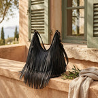 Black black leather fringe bag styled in a warm Mediterranean setting