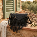 Black black leather fringe crossbody bag styled in a warm Mediterranean setting