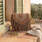 Khaki bohemian fringe crossbody bag styled in a warm Mediterranean setting