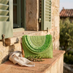 Green boho fringe bag clutch styled in a warm Mediterranean setting