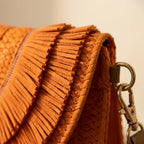 Close-up of fringe stitching and texture on Orange boho fringe bag clutch