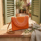 Orange boho fringe bag clutch styled in a warm Mediterranean setting