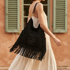 Woman wearing Black boho leather fringe bag with swaying fringe