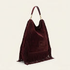 Maroon boho leather fringe bag, three-quarter angle showing side depth