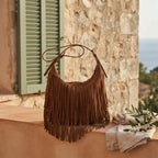 Brown brown fringe suede bag styled in a warm Mediterranean setting