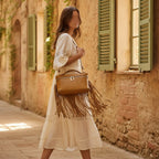Woman wearing Golden Brown brown leather shoulder bag with fringe with swaying fringe