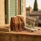 Light Brown brown satchel bag with fringe styled in a warm Mediterranean setting