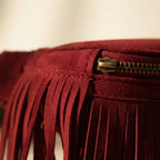 Close-up of fringe stitching and texture on Red burgundy fringe bag