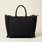 Back panel of Black canvas fringe tote bag with strap attachments
