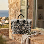 Leopard canvas fringe tote bag styled in a warm Mediterranean setting