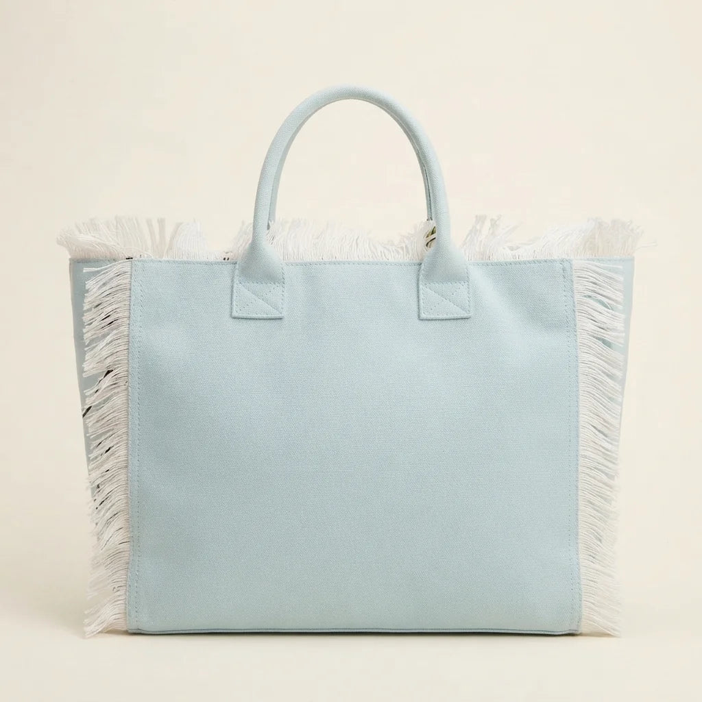 Back panel of Light Blue canvas fringe tote bag with strap attachments