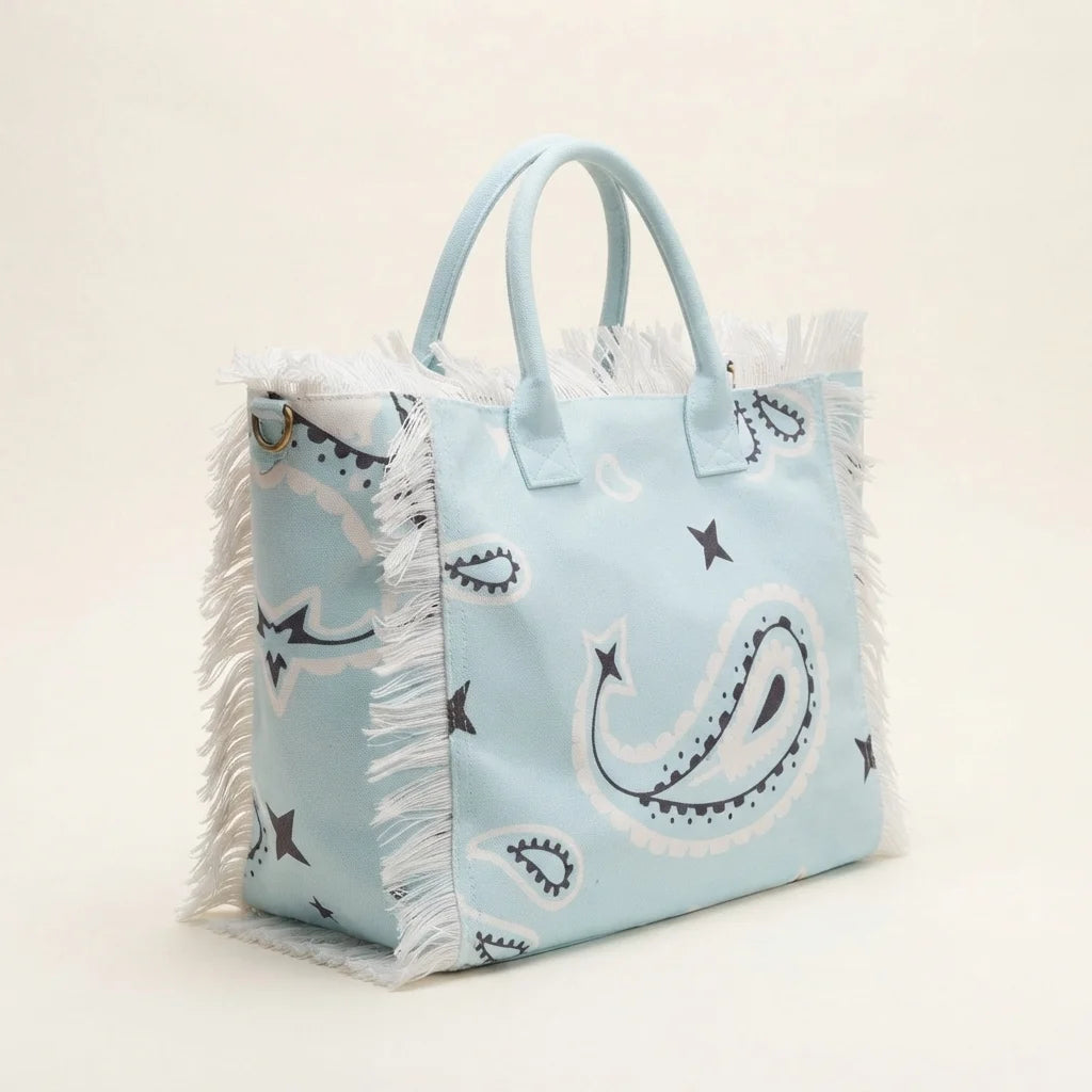 Light Blue canvas fringe tote bag, three-quarter angle showing side depth