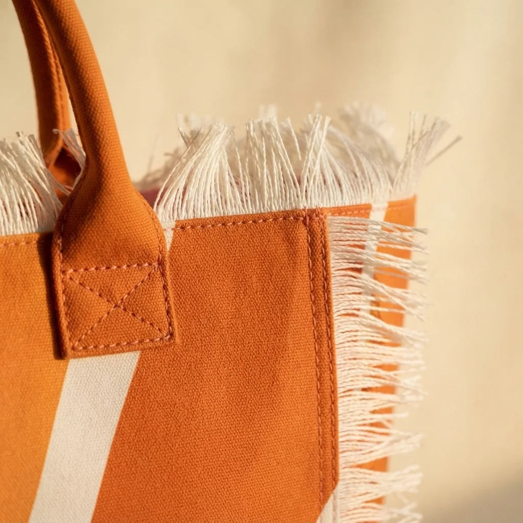 Close-up of fringe stitching and texture on Orange canvas fringe tote bag