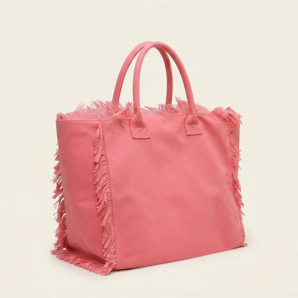 Pink canvas fringe tote bag, three-quarter angle showing side depth