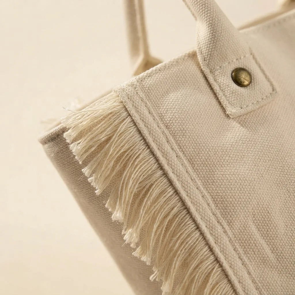 Close-up of fringe stitching and texture on White canvas fringe tote bag