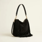 Black cowhide bag with fringe, three-quarter angle showing side depth