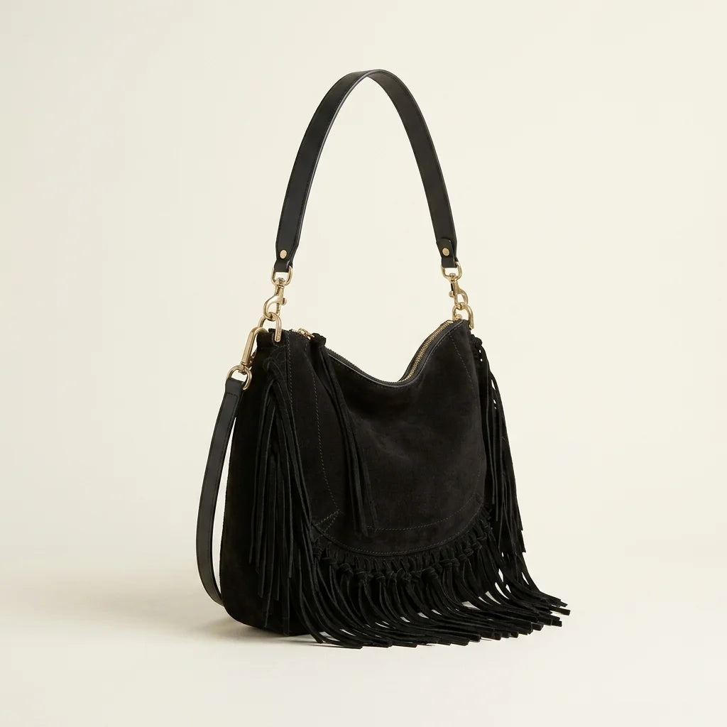 Black cowhide bag with fringe, three-quarter angle showing side depth