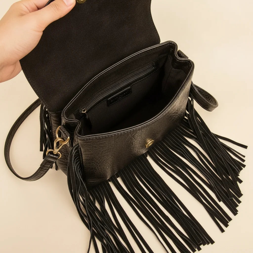 Interior lining and pockets of Black cowhide crossbody bag with fringe
