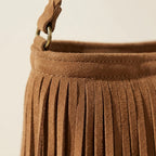Close-up of fringe stitching and texture on camel suede fringe crossbody bag