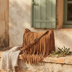 camel suede fringe crossbody bag styled in a warm Mediterranean setting