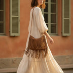 Woman wearing camel suede fringe crossbody bag with swaying fringe