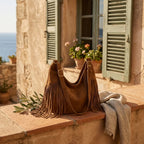 Brown dark brown suede fringe bag styled in a warm Mediterranean setting
