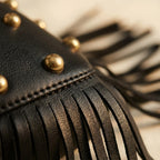 Close-up of fringe stitching and texture on Black faux leather fringe hobo bag