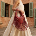 Woman wearing Wine Red faux leather fringe hobo bag with swaying fringe