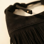 Close-up of fringe stitching and texture on Black faux suede fringe bag