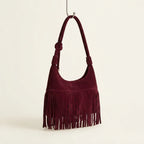 Burgundy faux suede fringe bag, three-quarter angle showing side depth