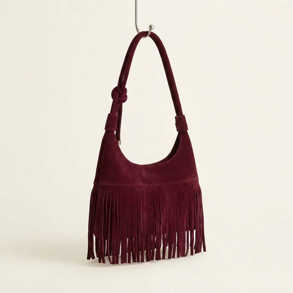 Burgundy faux suede fringe bag, three-quarter angle showing side depth