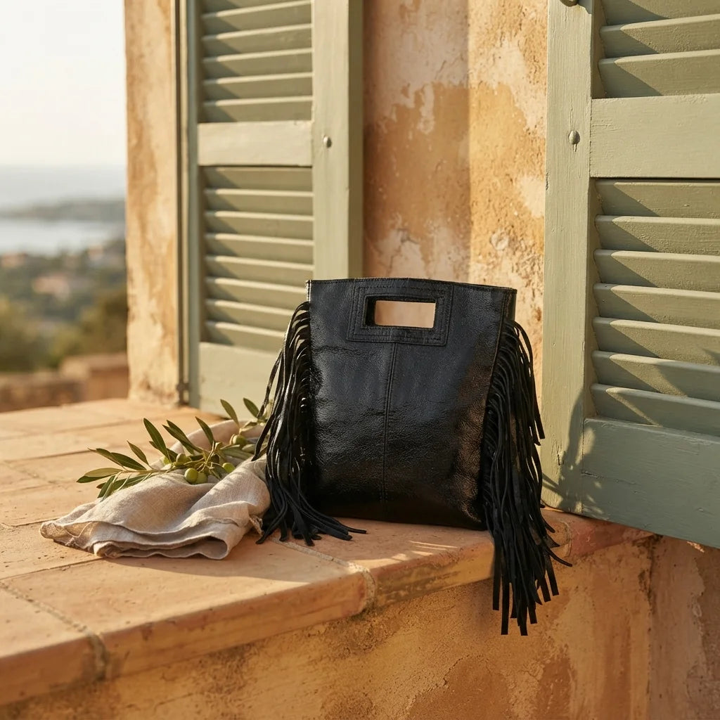 Black fringe backpack shoulder bag styled in a warm Mediterranean setting