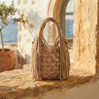 Beige fringe-clutch-bag-designer styled in a warm Mediterranean setting