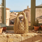 Gold fringe-clutch-bag-designer styled in a warm Mediterranean setting
