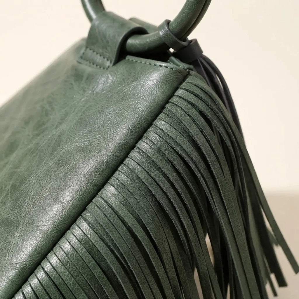 Close-up of fringe stitching and texture on Green fringe clutch bag leather