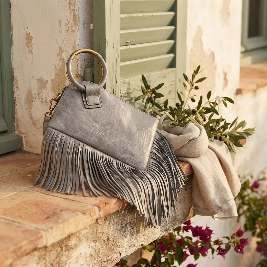 Grey fringe clutch bag leather styled in a warm Mediterranean setting