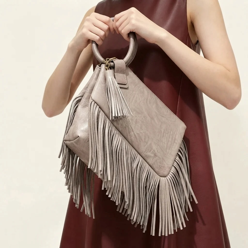 Grey fringe clutch bag leather, three-quarter angle showing side depth
