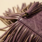 Close-up of fringe stitching and texture on Purple fringe clutch bag leather