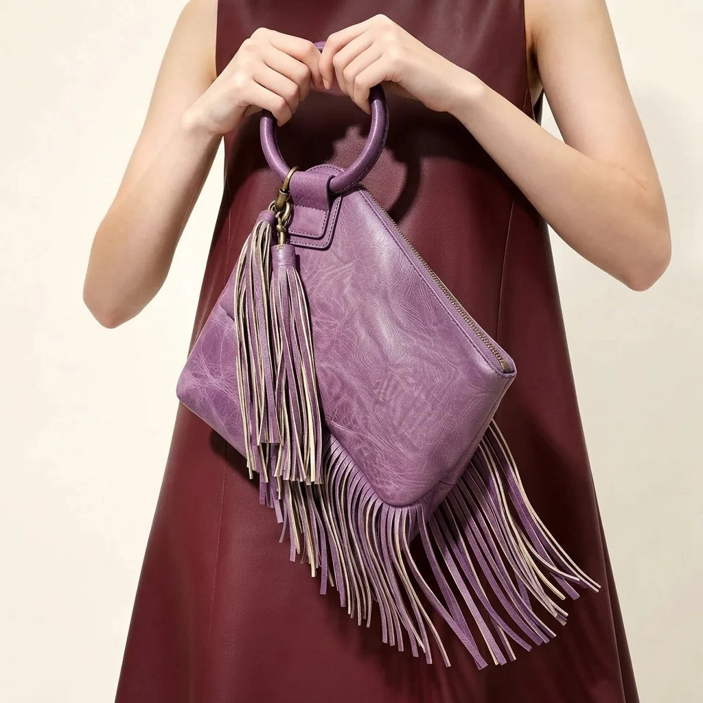 Purple fringe clutch bag leather, three-quarter angle showing side depth
