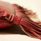 Close-up of fringe stitching and texture on Red fringe clutch bag leather