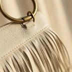 Close-up of fringe stitching and texture on White fringe clutch bag leather