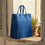 Blue fringe large tote bag styled in a warm Mediterranean setting