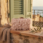 Pink fringe mini bag styled in a warm Mediterranean setting