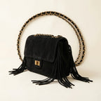Black fringe over shoulder bag, three-quarter angle showing side depth