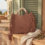 Brown fringe shoulder bag with tassels styled in a warm Mediterranean setting
